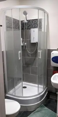 a shower in a bathroom with a toilet and a sink at LFC Stadium Apartment 1 in Liverpool