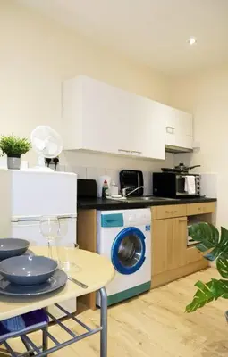 a kitchen with a table and a washing machine at LFC Stadium Apartment 2 in Liverpool