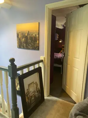 a hallway with a stairway with a picture in a frame at Tuebrook Towers in Liverpool