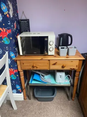 a microwave sitting on top of a wooden table at Tuebrook Towers in Liverpool