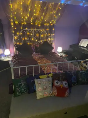 a bedroom with a bed with lights and pillows at Tuebrook Towers in Liverpool