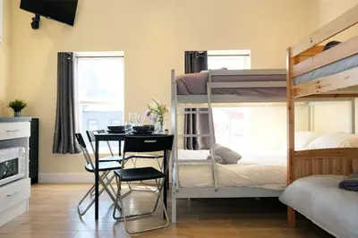 a bedroom with bunk beds and a table and chairs at LFC Stadium Apartment 3 in Liverpool