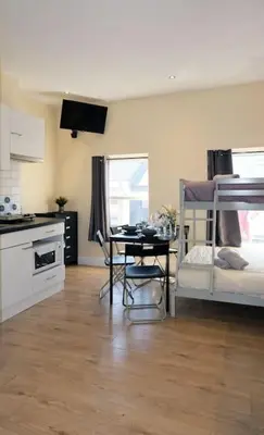 a room with a kitchen and a table and bunk beds at LFC Stadium Apartment 3 in Liverpool