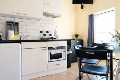 a kitchen with white appliances and a table with chairs at LFC Stadium Apartment 3 in Liverpool