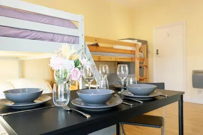 a dining table with bowls and glasses and a bed at LFC Stadium Apartment 3 in Liverpool