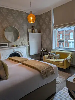 a bedroom with a bed and a couch and a fireplace at Merchant House in Bootle