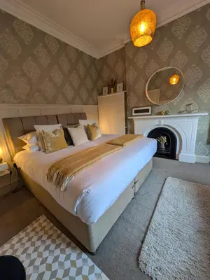 a bedroom with a large bed and a fireplace at Merchant House in Bootle