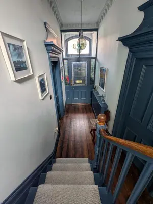a staircase in a house with a blue door at Merchant House in Bootle