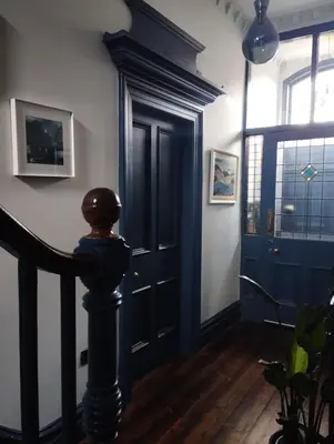 a hallway with a blue door and a wooden floor at Merchant House in Bootle