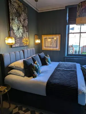 a bedroom with a large bed with blue walls at Merchant House in Bootle