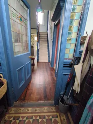 a hallway with a blue door and a wooden floor at Merchant House in Bootle