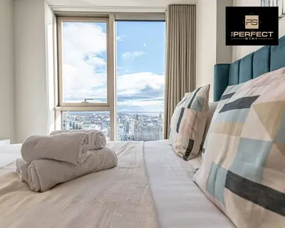 a bedroom with a bed with a large window at The Lexington - Luxury Serviced Apartments City Centre - City and Waterfront views in Liverpool