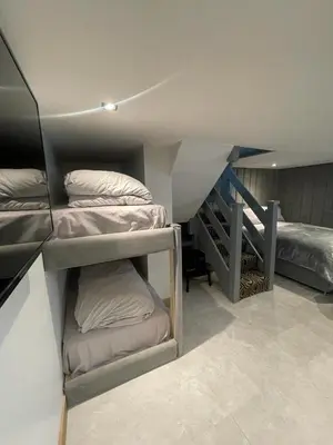 a room with three bunk beds and a staircase at Belvedere Aparthotel - 83 Mount Pleasant in Liverpool
