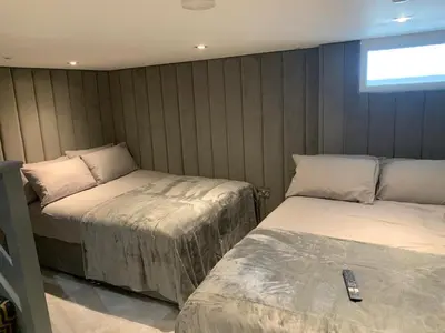 a bedroom with two beds with a remote control on it at Belvedere Aparthotel - 83 Mount Pleasant in Liverpool