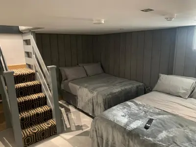 a bedroom with two beds and a staircase in it at Belvedere Aparthotel - 83 Mount Pleasant in Liverpool