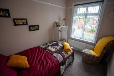 a bedroom with a bed and a chair and a window at Dalmore - Quiet residence with long driveway at M6 Preston in Samlesbury