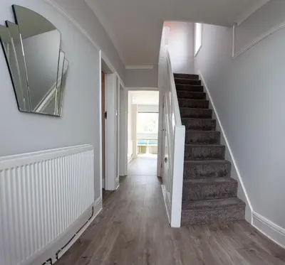 a hallway with stairs and a mirror on the wall at Dalmore - Quiet residence with long driveway at M6 Preston in Samlesbury