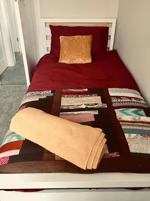 a bed with a red comforter and a blanket at Dalmore - Quiet residence with long driveway at M6 Preston in Samlesbury