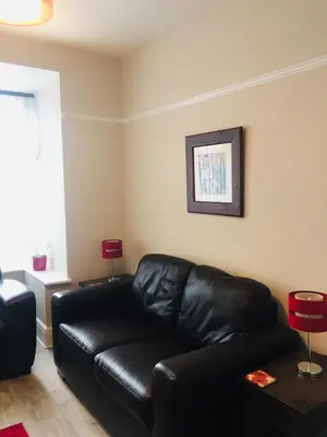 a black leather couch in a living room at Dalmore - Quiet residence with long driveway at M6 Preston in Samlesbury