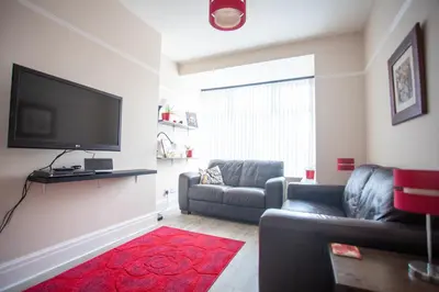 a living room with a couch and a flat screen tv at Dalmore - Quiet residence with long driveway at M6 Preston in Samlesbury