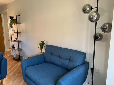 a blue couch in a living room with a lamp at The 9th Hole - Two-Bedroom Apartment in Birkdale, 1 mile from Royal Birkdale Golf Club in Southport
