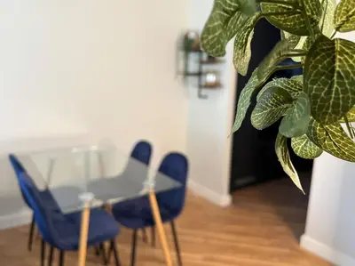 a table and chairs and a plant in a room at The 9th Hole - Two-Bedroom Apartment in Birkdale, 1 mile from Royal Birkdale Golf Club in Southport