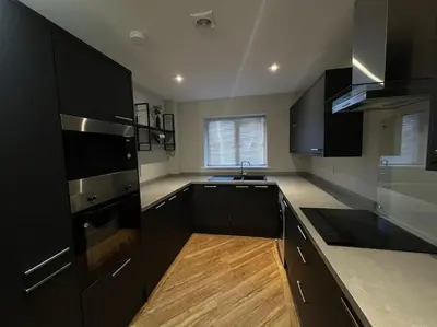 a kitchen with black appliances and a wooden floor at The 9th Hole - Two-Bedroom Apartment in Birkdale, 1 mile from Royal Birkdale Golf Club in Southport