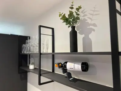 a black shelf with a bottle of wine and a vase at The 9th Hole - Two-Bedroom Apartment in Birkdale, 1 mile from Royal Birkdale Golf Club in Southport
