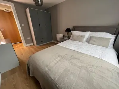 a bedroom with a large bed and a dresser at The 9th Hole - Two-Bedroom Apartment in Birkdale, 1 mile from Royal Birkdale Golf Club in Southport