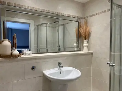 a bathroom with a sink and a mirror at The 9th Hole - Two-Bedroom Apartment in Birkdale, 1 mile from Royal Birkdale Golf Club in Southport