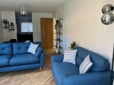 a living room with two blue couches at The 9th Hole - Two-Bedroom Apartment in Birkdale, 1 mile from Royal Birkdale Golf Club in Southport
