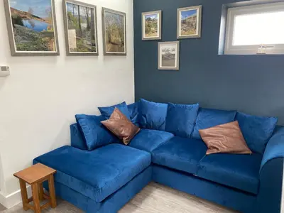 a blue couch with pillows on it in a living room at New purpose built holiday lodge in Scorton