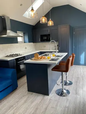 a kitchen with blue cabinets and a counter with a sink at New purpose built holiday lodge in Scorton