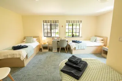 a room with two beds and a desk in it at Theodore House in Clitheroe