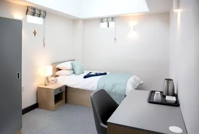 a small room with a bed and a desk at Theodore House in Clitheroe
