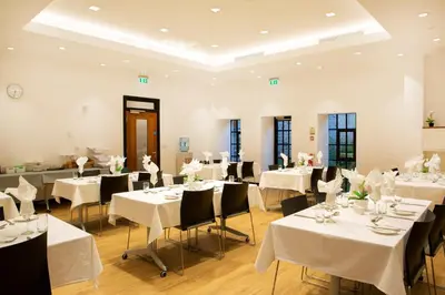 a banquet hall with white tables and chairs at Theodore House in Clitheroe