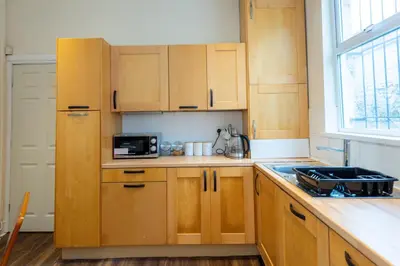 a kitchen with wooden cabinets and a counter top at 10 Guests - Free Parking - City Centre in Liverpool