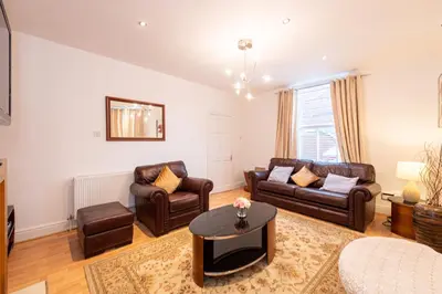 a living room with leather furniture and a table at 10 Guests - Free Parking - City Centre in Liverpool