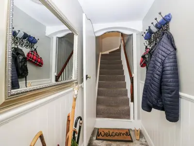 a hallway with a mirror and a staircase at Cartmel Flat in Grange Over Sands