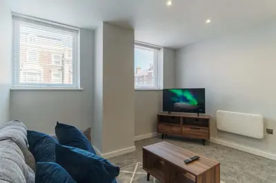 a living room with a couch and a flat screen tv at Modern 1 Bedroom Apartment in Liverpool in Liverpool