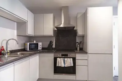 a kitchen with white cabinets and a stove top oven at Modern 1 Bedroom Apartment in Liverpool in Liverpool
