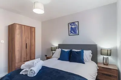 a bedroom with a bed with blue and white pillows at Modern 1 Bedroom Apartment in Liverpool in Liverpool
