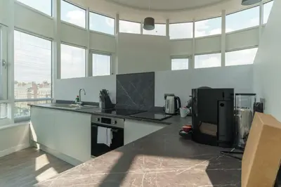 a kitchen with a stove and a sink and windows at Stunning 2 Bedroom Apartment in Liverpool in Liverpool
