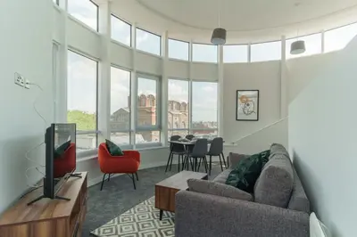 a living room with a couch and a tv and a table at Stunning 2 Bedroom Apartment in Liverpool in Liverpool