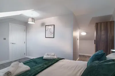 a bedroom with a large bed with green sheets at Stunning 2 Bedroom Apartment in Liverpool in Liverpool