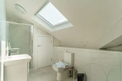 a bathroom with a toilet and a sink and a skylight at Stunning 2 Bedroom Apartment in Liverpool in Liverpool
