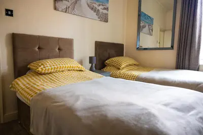 two twin beds in a room with a mirror at COZY PLACE LIVERPOOL in Liverpool