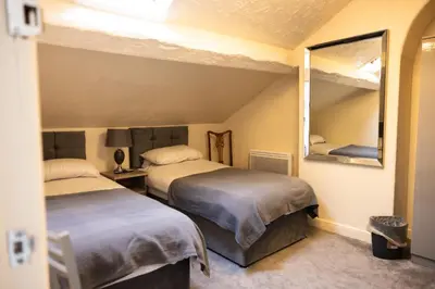 a room with two beds and a mirror at COZY PLACE LIVERPOOL in Liverpool
