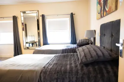a bedroom with two beds and a large window at COZY PLACE LIVERPOOL in Liverpool