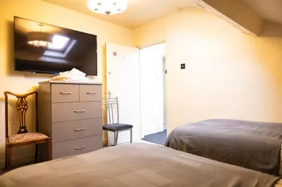 a bedroom with a bed and a dresser with a tv at COZY PLACE LIVERPOOL in Liverpool